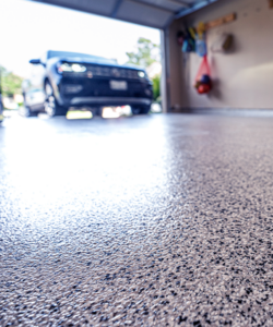 dark vehicle driving into garage with black and white epoxy floor